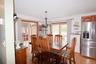Dining area featuring wood-finish flooring, a contemporary chandelier, and a stainless steel refrigerator