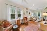 Living area with a baseboard radiator, ceiling fan, light wood-style floors, baseboard heating, and ornamental molding
