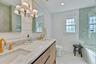 Full bath with healthy amount of natural light, shower / washtub combination, double vanity, light tile patterned flooring, and recessed lighting