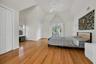 Bedroom featuring light wood-style floors, visible vents, vaulted ceiling, and baseboards