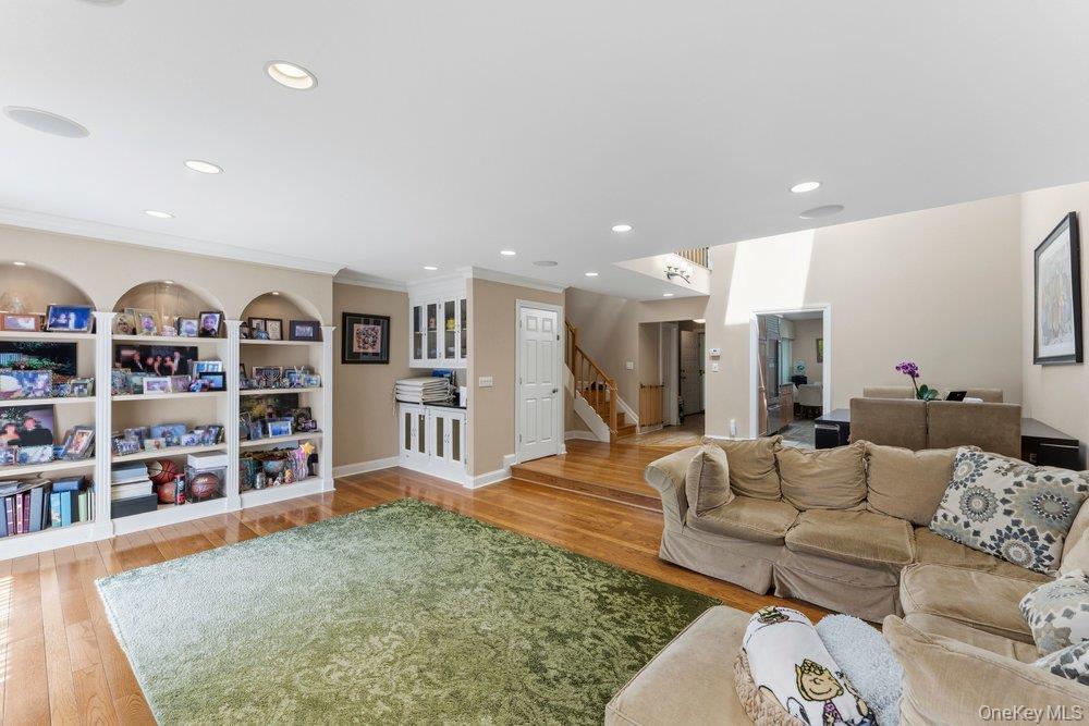 Living area featuring wood-finish flooring, recessed lighting, and integrated ceiling speakers