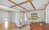 Living room with a barn door, light wood-style flooring, and ornamental molding