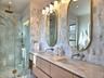 Full bath featuring double vanity, a marble finish shower, and a sink