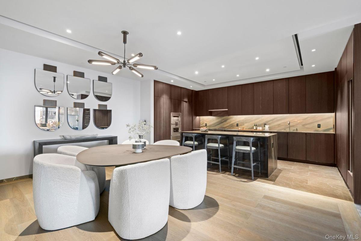 Dining area with an inviting chandelier, light wood-style floors, and recessed lighting