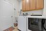 Laundry room with cabinet space, washing machine and dryer, and light tile patterned floors