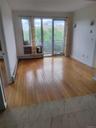 Unfurnished living room featuring a baseboard radiator and light wood-type flooring