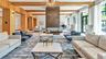 The residents' lounge serves as the heart of the amenity spaces, featuring a cozy fireplace and an elegant piano.