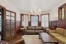 Living room featuring a wainscoted wall, wood finished floors, a chandelier, and radiator
