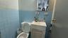 Bathroom featuring vanity, toilet, and tile walls