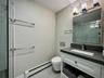 Bathroom with baseboard heating, vanity, light tile patterned floors, and a stall shower