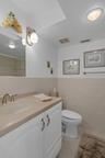 En-suite bath features single vanity with Corian countertop and a storage cabinet + drawer