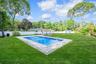 View of swimming pool with a fenced backyard, an outbuilding, a patio area, and view of scattered trees