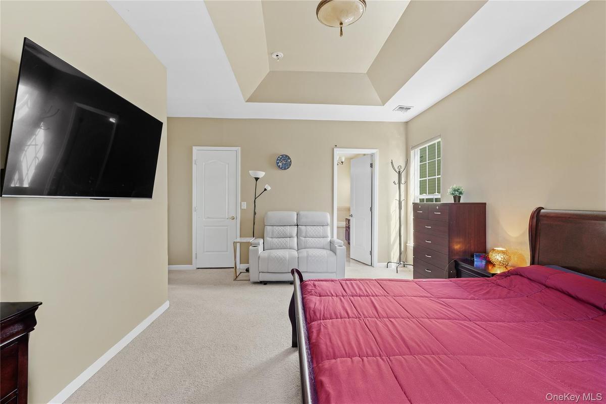 First Floor Recessed ceiling with layered trim, neutral wall color, and light-toned carpeting