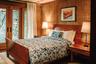 Bedroom with wood walls, access to outside