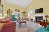 Living room with high vaulted ceiling, a high end fireplace, plenty of natural light, wood finished floors, and recessed lighting