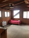 Carpeted bedroom with wooden walls, wood ceiling, and lofted ceiling with beams