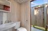 Bathroom featuring a sink, visible vents, toilet, and wooden walls