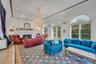Living room with a glass covered fireplace, recessed lighting, a chandelier, and crown molding