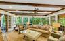 Southwest facing great room oozing with natural light, featuring beam ceiling, recessed lighting, french doors to den and back door leading to brick p