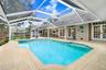 Custom shaped pool with swim seat, spa with spillover ledge feature.