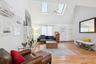 Living room with ceiling fan, high vaulted ceiling, plenty of natural light, and a tiled fireplace