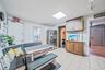 Kitchen with stainless steel refrigerator with ice dispenser, brown cabinetry, and light countertops
