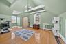 Additional living space with healthy amount of natural light, vaulted ceiling, light wood-style floors, a chandelier, and a baseboard heating unit
