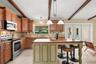 Rich wood cabinetry, abundant counter space, a center island, SLEEK TILE BACKSPLASH, stainless steel appliances, a closet pantry, and a spacious Break