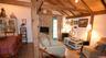 Vaulted wood-plank ceilings with exposed beams, wood-finish flooring, and a dining area featuring a built-in display cabinet