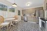 Kitchen with stainless steel appliances, tasteful backsplash, hanging light fixtures, crown molding, and a baseboard heating unit
