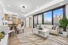 Living room with light wood-style floors, recessed lighting, baseboards, and a tray ceiling