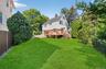 Back of house featuring a fenced backyard, a chimney, a deck, and stairway
