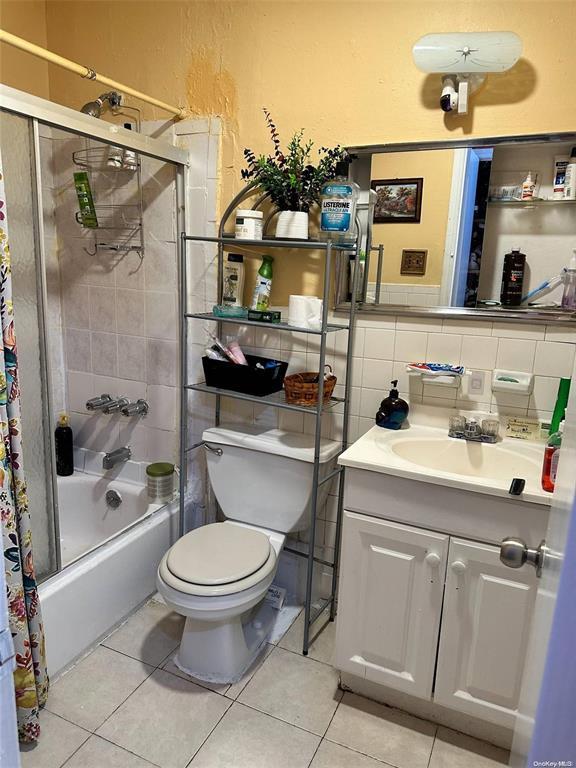 Full bath featuring toilet,  shower combination, vanity, and tile patterned floors