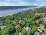 Aerial overview of property's location with a large body of water and a forest