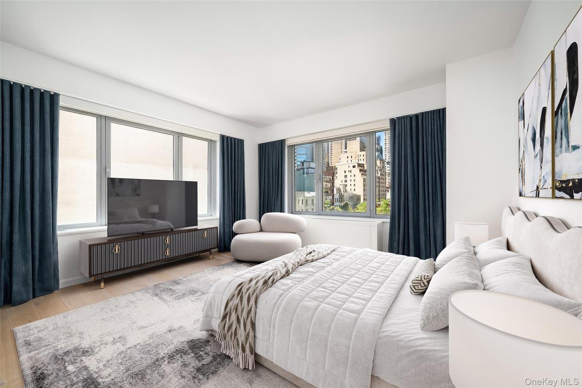 Bright room featuring light wood-finish flooring, a full wall of windows with dark drapery, and a contemporary media console