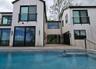 Back of property featuring an outdoor pool and a deck
