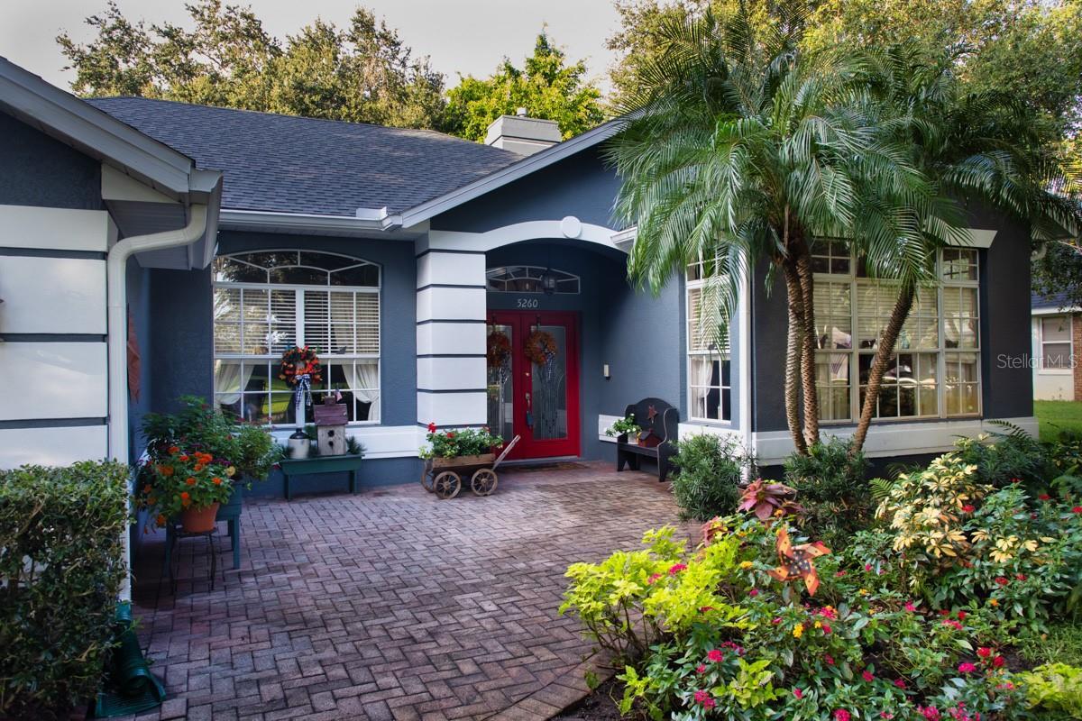 Spacious front paver patio with mature landscaping