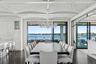 Dining space with a chandelier, dark wood-style flooring, a water view, and plenty of natural light