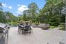 View of patio / terrace featuring an outdoor pool, outdoor dining space, view of wooded area, area for grilling, and an outdoor living space