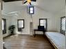 5 - Unfurnished bedroom featuring baseboards, high vaulted ceiling, multiple windows, and wood finished floors