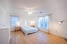 Bedroom featuring baseboards, light wood-style flooring, visible vents, and crown molding