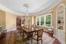 Dining space with built in shelves, dark wood-style floors, stairway, crown molding, and a chandelier