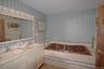 Built-in soaking tub with a tiled surround featuring decorative mosaic accents