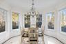 Sunroom with inlaid floor details, a chandelier, and crown molding