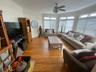 Living room with light hardwood / wood-style floors, ceiling fan, and crown molding