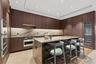 Kitchen with a breakfast bar area, light countertops, appliances with stainless steel finishes, a warming drawer, and modern cabinets