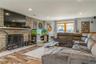 Living room with wood-type flooring and a stone fireplace