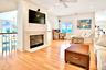 Living area featuring an office area, ornamental molding, light wood-style flooring, a glass covered fireplace, and recessed lighting