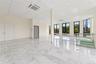Unfurnished room featuring a paneled ceiling, light marble finish flooring, and baseboards