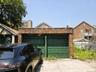 Brick two-car garage with green garage doors